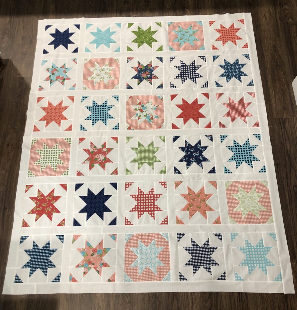 Anna-Marie's quilt with a white border and colorful stars and triangles