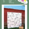 A Lincoln Logs quilt from Yellow Umbrella Quilts hanging on the side of a barn.