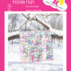 A beautiful and colorful quilt from Yellow Umbrella Quilts hanging from a branch surrounded by snow.